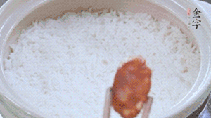 煮開后轉小火，當米飯出現(xiàn)小孔時，鋪上金字麻辣香腸。
