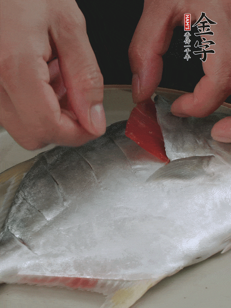 火腿片和姜片塞在刀口處，也塞一些入魚(yú)肚。