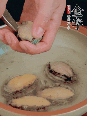 鮑魚加鹽、清水浸泡，用勺子挖出鮑魚肉。