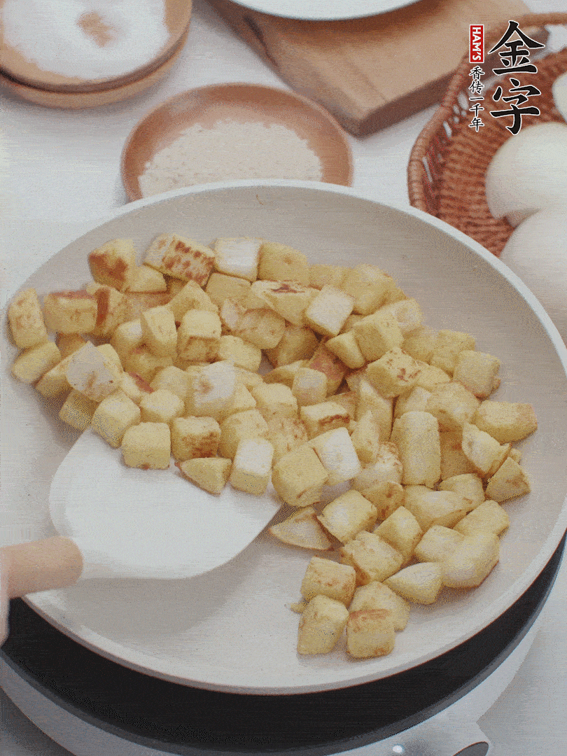 起鍋熱油，倒入饅頭丁，小火煎至蛋液凝固定型再翻面，饅頭丁部煎至金黃時盛起待用。