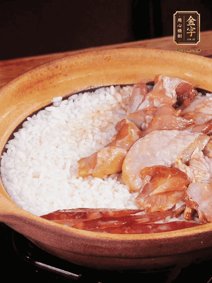 煮到椰子水微微收干轉(zhuǎn)小火，快速均勻鋪上雞肉、金字香腸