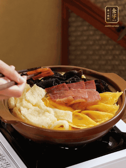 砂鍋底部鋪上娃娃菜，依次擺上肉皮、蛋餃、黑木耳、火腿